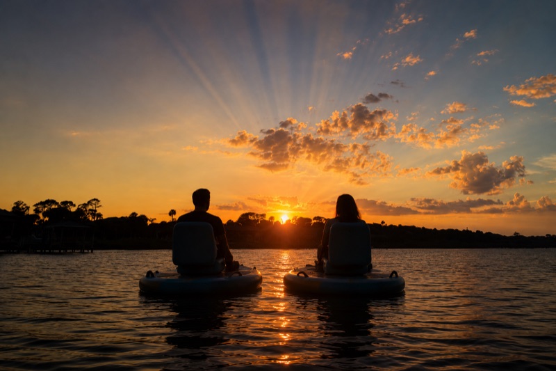 Couple on two GoBoats watching a golden sunset over the calm Intracoastal